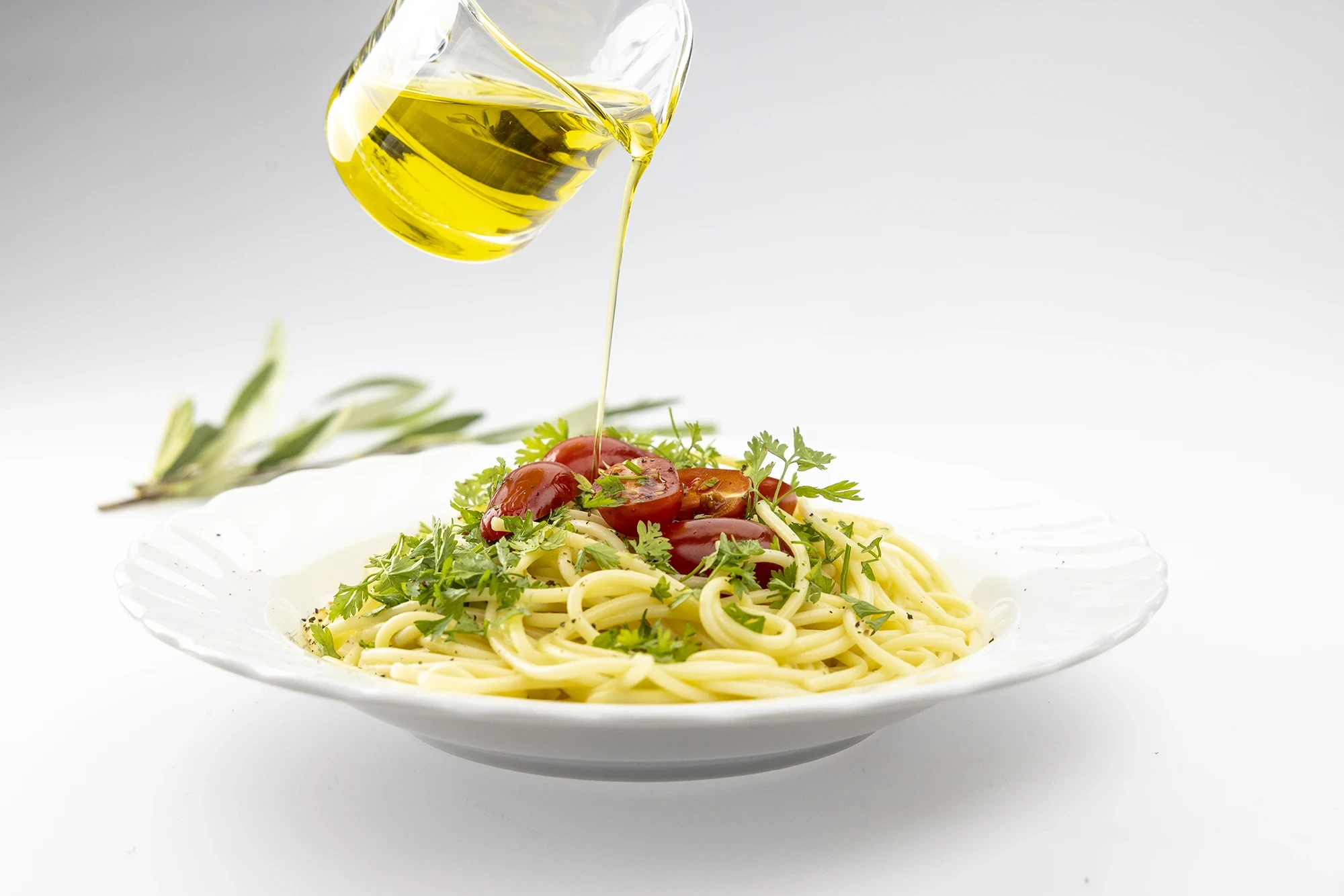 Pasta mit Tomaten und frischen Kräutern. Olivenöl wird drauf gegossen.